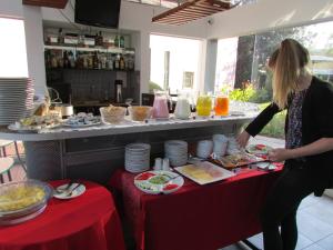 a woman standing in front of a table with food at Queen's Villa Hotel Boutique in Arequipa