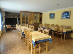 comedor con mesas y sillas y chimenea en Casa Os Batans, en Vimianzo