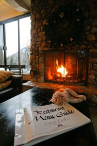 a book on a table in front of a fireplace at Hotel Aspen in Aspen
