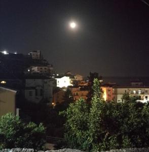 luna llena sobre una ciudad por la noche en Garden Bijou with Sea View, en Vietri