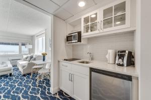 a kitchen with white cabinets and a living room at ICONA Cape May in Cape May