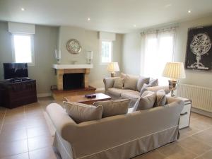 a living room with two couches and a fireplace at La Villa a Chateau Franc-Daut Sleeps 6 in Saint-Magne-de-Castillon