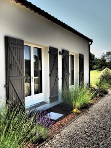 a house with sliding doors and grass at La Villa a Chateau Franc-Daut Sleeps 6 in Saint-Magne-de-Castillon