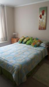 1 dormitorio con 1 cama con edredón azul en Departamento Laguna Vista Algarrobo, en Algarrobo