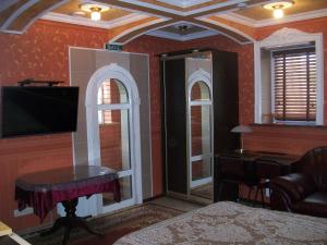 a bedroom with red walls and a table and a tv at atHome in Sumy