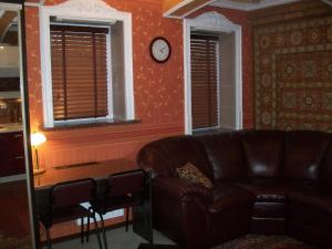 a living room with a couch and a clock on the wall at atHome in Sumy