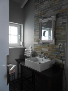 ein Badezimmer mit einem Waschbecken und einer Ziegelwand in der Unterkunft Le Haut de l'Espérance in Uffholtz
