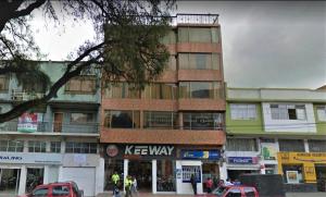 un edificio alto en una calle de la ciudad con coches delante en Hotel Juanambu, en Pasto