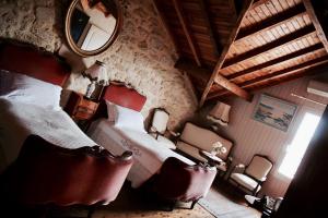 a bedroom with a bed and a mirror and chairs at Le Manoir de Marie-Lou in Rauzan