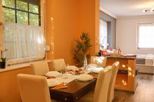 a dining room with a table and chairs in a room at Centrum Luxus Apartman in Makó