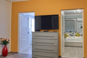 een kamer met een dressoir en een slaapkamer met een bed bij Centrum Luxus Apartman in Makó