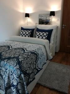 Un dormitorio con una cama con sábanas y almohadas azules y blancas en Apartament, en Radom