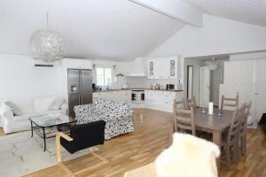 eine Küche und ein Wohnzimmer mit einem Tisch und Stühlen in der Unterkunft Villa near Åhus in Yngsjö