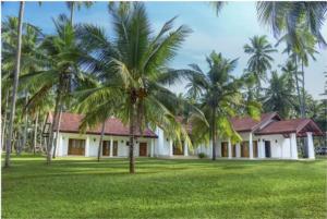 una casa con palme di fronte di Coco Villa Peach Tree a Katunayake