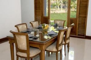 a dining room with a table with chairs and a window at Coco Villa Peach Tree in Katunayaka