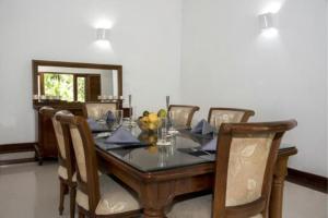 a dining room with a table with chairs at Coco Villa Peach Tree in Katunayaka