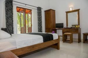 a bedroom with a bed and a desk and a mirror at Coco Villa Peach Tree in Katunayaka