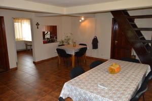 a dining room with a table and chairs and a staircase at Cabana Ada 2 in Vartop