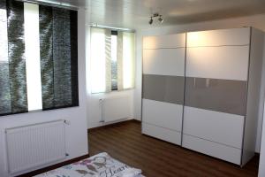 ヴェークベルクにあるFewo Weitsichtの白い大きなキャビネットと窓が備わる客室です。