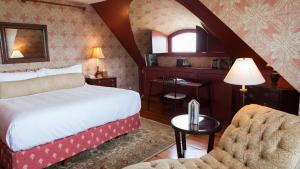 a bedroom with a bed and a desk and a chair at Castle Hill Inn in Newport