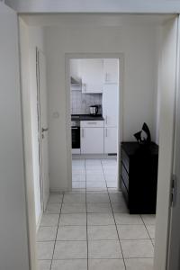 a white kitchen with a door open to a room at Fewo Weitsicht in Wegberg