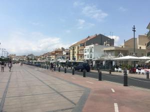 a city street with people walking on the sidewalk at Club Nautic in Cambrils