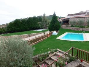 a garden with a swimming pool and a house at Casa Dona Urraca in Vilarinho da Castanheira