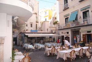un gruppo di tavoli e sedie in una strada con edifici di La Rosa dei Venti - Scirocco ad Amalfi