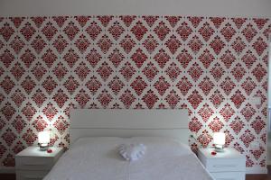 1 dormitorio con 1 cama blanca y 2 mesitas de noche en Villa Goria, en Pontestura