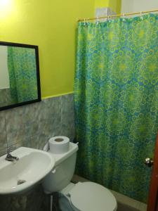 a bathroom with a toilet and a shower curtain at Francisco Habitaciones in Manta