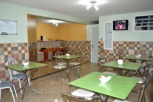 a restaurant with tables and chairs in a room at Pousada Alto Riviera in Macaé