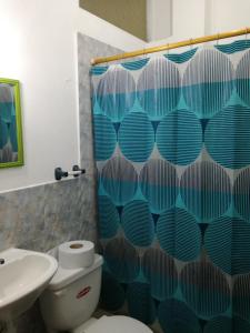 a bathroom with a toilet and a shower curtain at Francisco Habitaciones in Manta