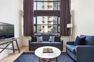 ein Wohnzimmer mit Sofa und Fernseher in der Unterkunft Surry Hills Modern One Bedroom Apartment -GOUL in Sydney