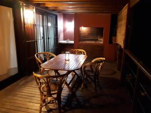 Una mesa y sillas de madera en una habitación. en La Gringa, un espacio único en el medio del bosque, en Mar de las Pampas