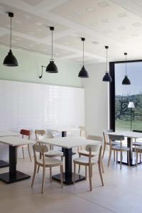 a dining room with white tables and chairs at Hotel-Bodega Finca de Los Arandinos in Entrena