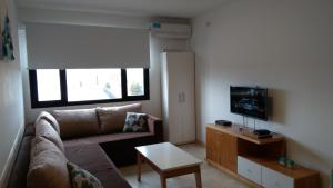 a living room with a couch and a tv at Tu Hogar en Neuquen in Neuquén