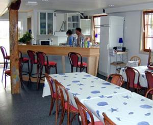 cocina con mesa, sillas y barra en Vimmerby Vandrarhem en Vimmerby