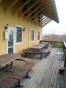 una terraza con mesas de madera y bancos en un edificio en Vimmerby Vandrarhem en Vimmerby