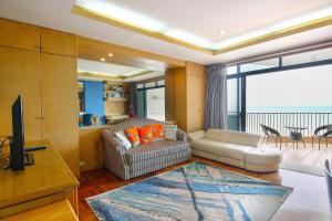 a living room with a couch and a television at Cha am Beach Club in Phetchaburi