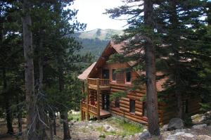 una cabaña de madera en el bosque con árboles en The Silver Lake Lodge - Adults Only, en Idaho Springs