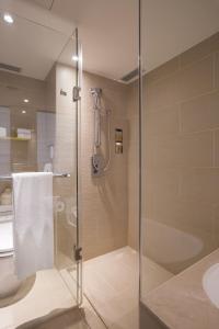 uma casa de banho com uma cabina de duche em vidro e um WC. em Hotel COZZI Zhongxiao Taipei em Taipei