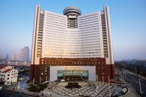 un grand bâtiment avec beaucoup de fenêtres dans l'établissement Huafang Jinling International Hotel Zhangjiagang, à Zhangjiagang