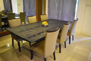 a black table with chairs and a bowl of fruit on it at 67 First Island in Bayan Lepas