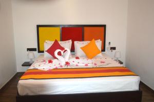 1 dormitorio con 1 cama grande y almohadas coloridas en Sigiri Resort, en Sigiriya