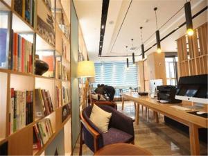 ein Büro mit einem Schreibtisch und eine Bibliothek mit Büchern in der Unterkunft Atour Hotel Shuangyong Ave in Yan'an