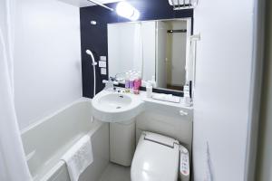 een witte badkamer met een wastafel en een toilet bij Sotetsu Fresa Inn Chiba Kashiwa in Kashiwa