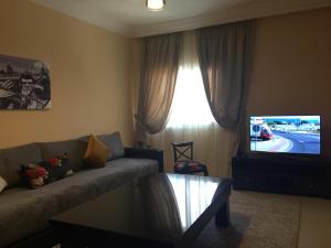 a living room with a couch and a tv at Résidence Tamaya in Dakhla
