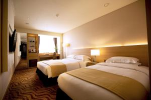 um quarto de hotel com duas camas e uma janela em Summit Hotel Seoul Dongdaemun em Seul