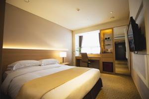 a hotel room with a large bed and a desk at Summit Hotel Seoul Dongdaemun in Seoul