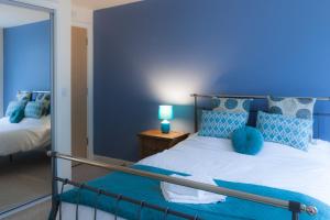 Cette chambre bleue comprend un lit et un miroir. dans l'établissement Hicking Dye Works, à Nottingham